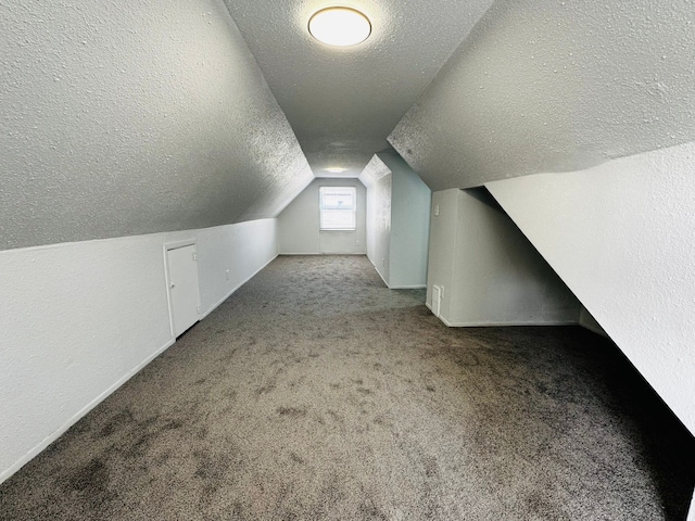 bonus room featuring lofted ceiling, a textured ceiling, and carpet flooring