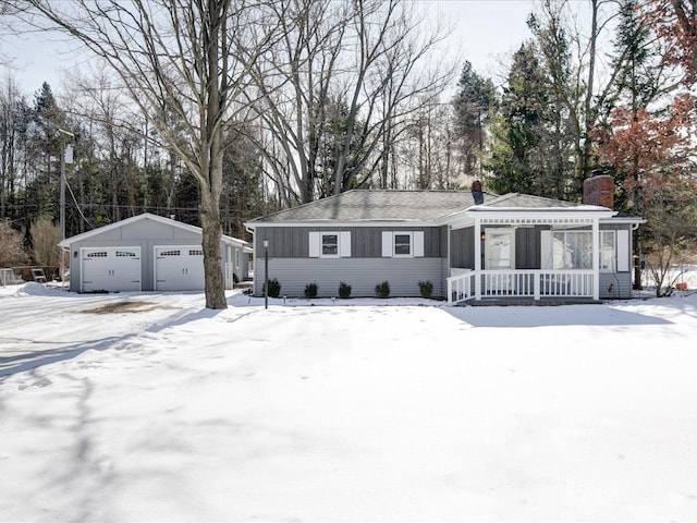 single story home with a garage, a porch, and an outbuilding