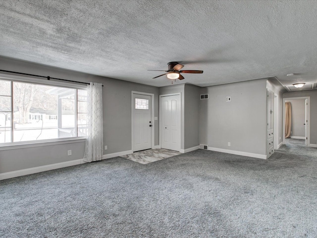 unfurnished living room featuring carpet floors, a textured ceiling, and ceiling fan