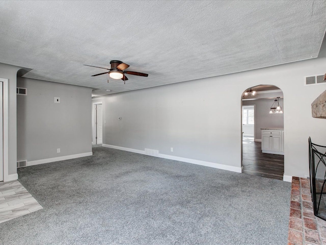 unfurnished living room with a textured ceiling, ceiling fan, and carpet flooring