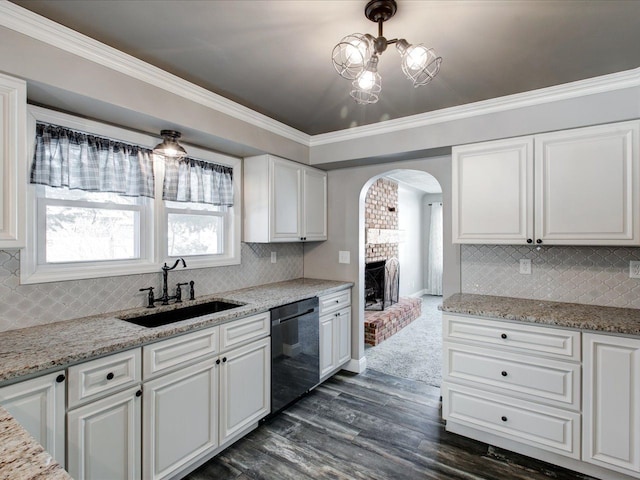 kitchen featuring black dishwasher, sink, white cabinets, and light stone counters