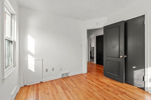 empty room with hardwood / wood-style flooring and a textured ceiling