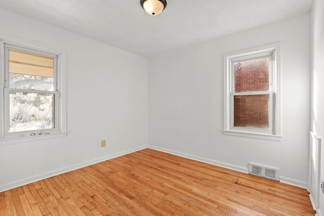 empty room featuring light hardwood / wood-style flooring and a textured ceiling