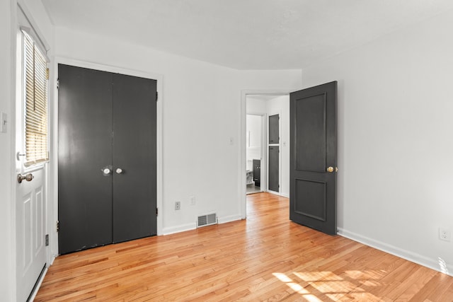 unfurnished bedroom featuring a closet and light wood-type flooring