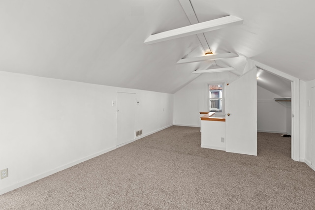 additional living space with vaulted ceiling and carpet flooring