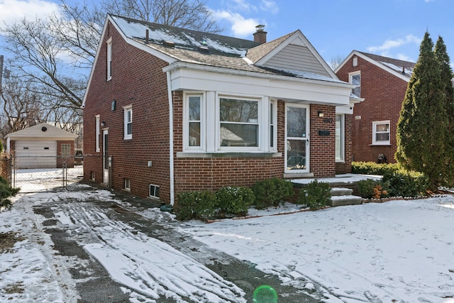 view of front of property with a garage and an outbuilding