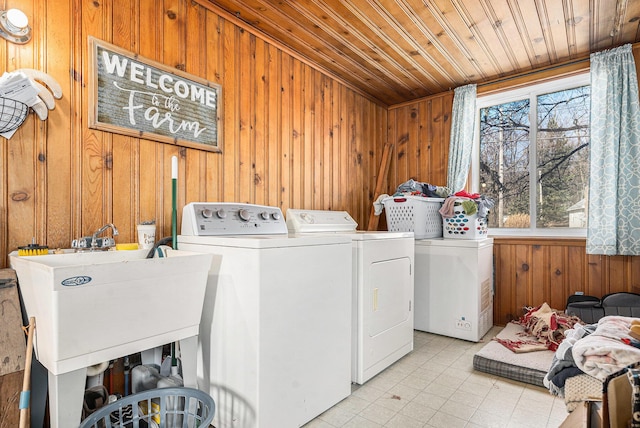 laundry area featuring washer and dryer, a sink, wood walls, wood ceiling, and laundry area