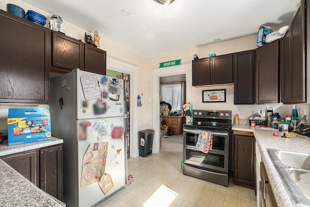 kitchen with range with two ovens, dark brown cabinets, light countertops, and freestanding refrigerator