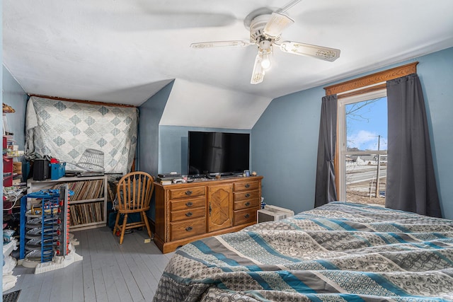 bedroom with lofted ceiling, a ceiling fan, and wood-type flooring