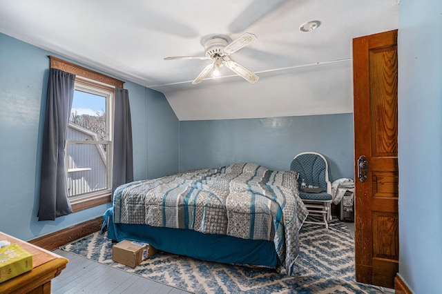 bedroom featuring baseboards, wood-type flooring, a ceiling fan, and vaulted ceiling