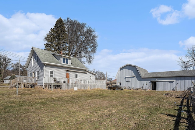 rear view of house with a barn, a chimney, an outdoor structure, and a lawn