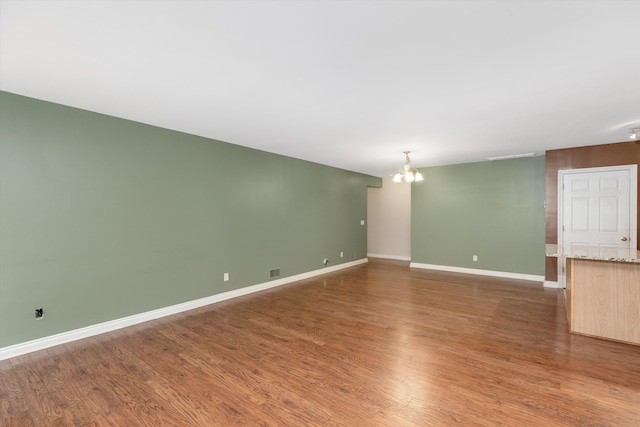 unfurnished living room with dark hardwood / wood-style flooring and a notable chandelier