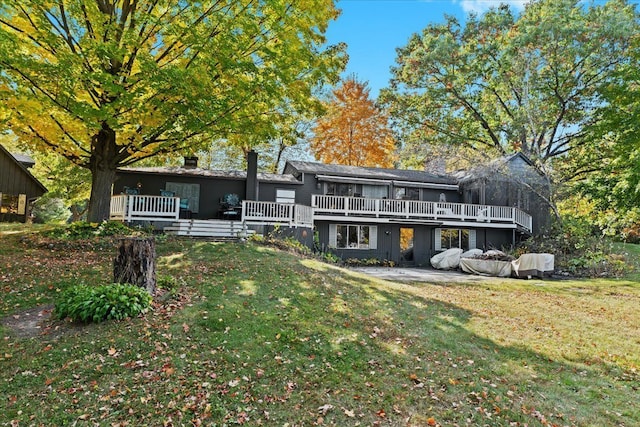 rear view of house featuring a yard and a deck