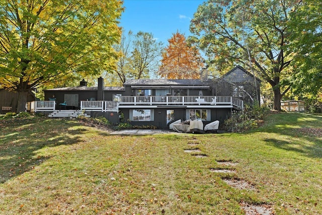 back of property with a wooden deck and a yard