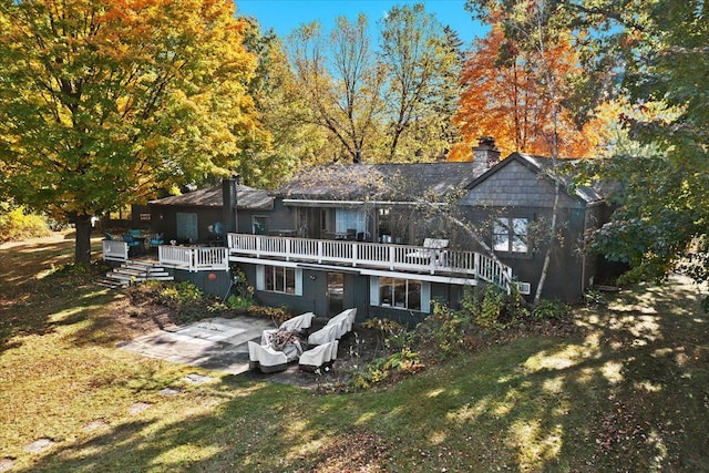 rear view of house featuring a wooden deck, a yard, and a patio