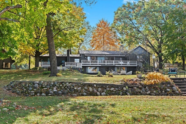 rear view of property featuring a wooden deck and a yard