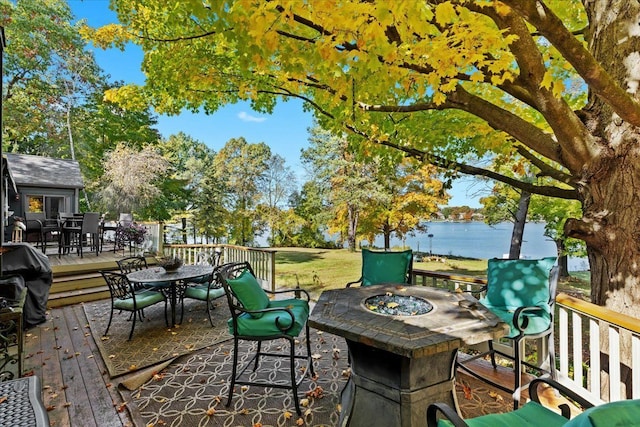 view of patio with a deck with water view, grilling area, and an outdoor fire pit