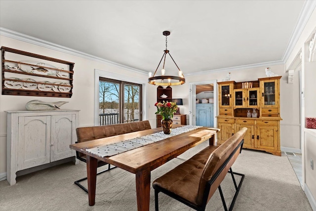 dining room with crown molding and light colored carpet