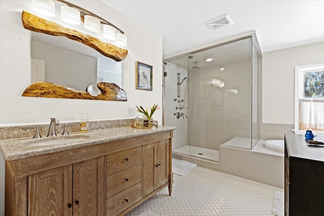 bathroom featuring tile patterned flooring, vanity, and walk in shower