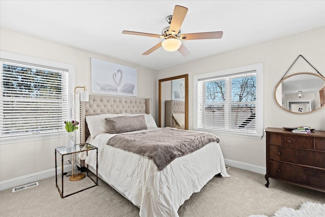 carpeted bedroom featuring multiple windows and ceiling fan