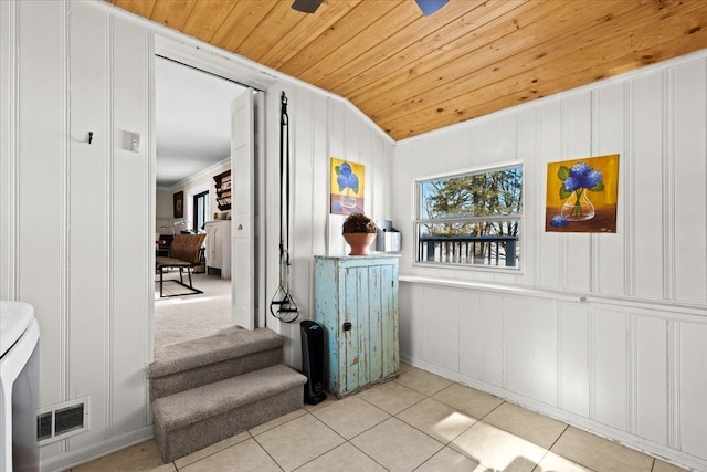 hall with light tile patterned flooring, lofted ceiling, crown molding, and wood ceiling