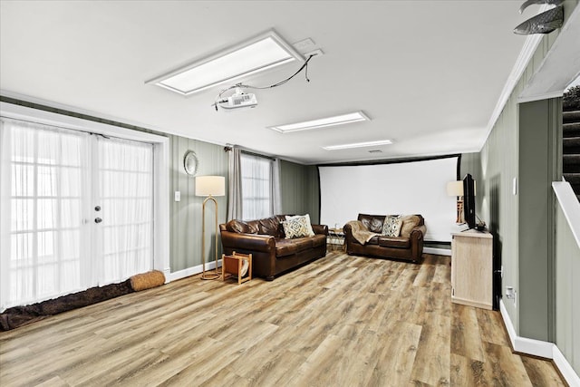 living room featuring baseboard heating, crown molding, and light hardwood / wood-style floors