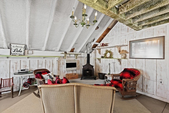 living room with concrete flooring, vaulted ceiling, and a wood stove