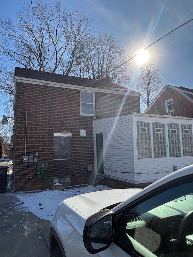 rear view of house with entry steps and brick siding