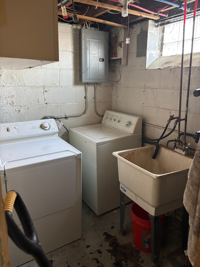 laundry room featuring electric panel, a sink, and washer and clothes dryer