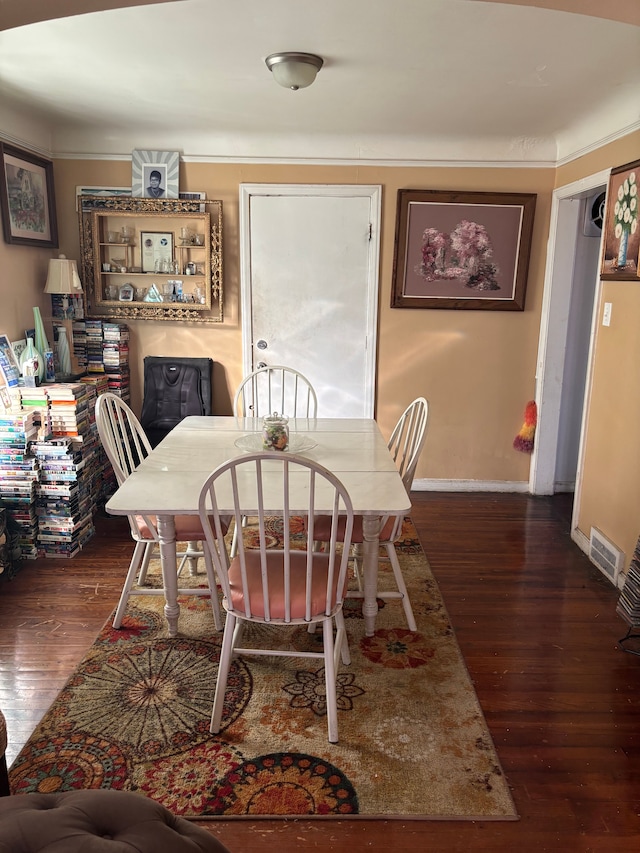 dining space with baseboards, visible vents, and wood finished floors