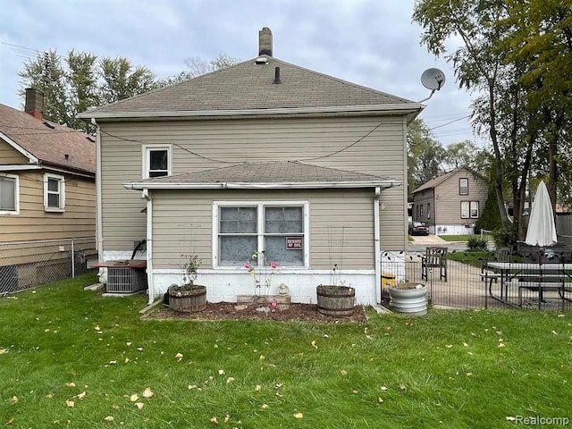 rear view of property featuring a yard and central AC unit