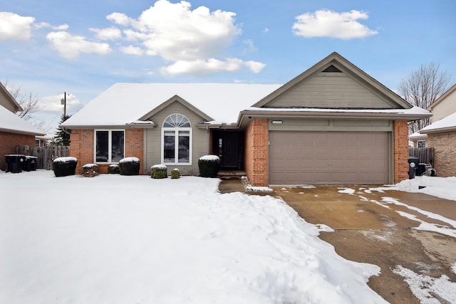 single story home with a garage, driveway, and brick siding