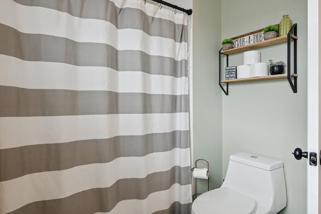 bathroom with toilet and a shower with curtain