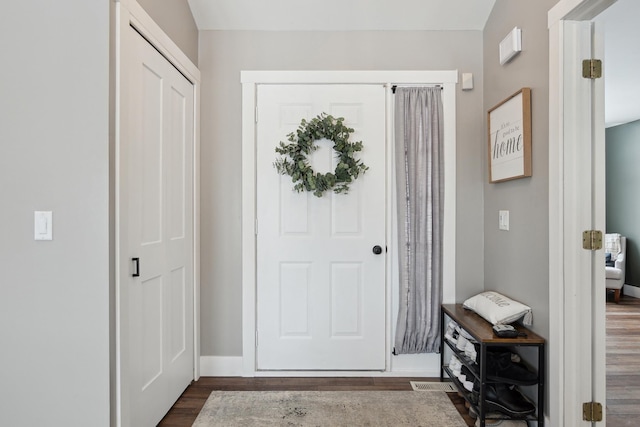 entryway with dark wood finished floors and baseboards