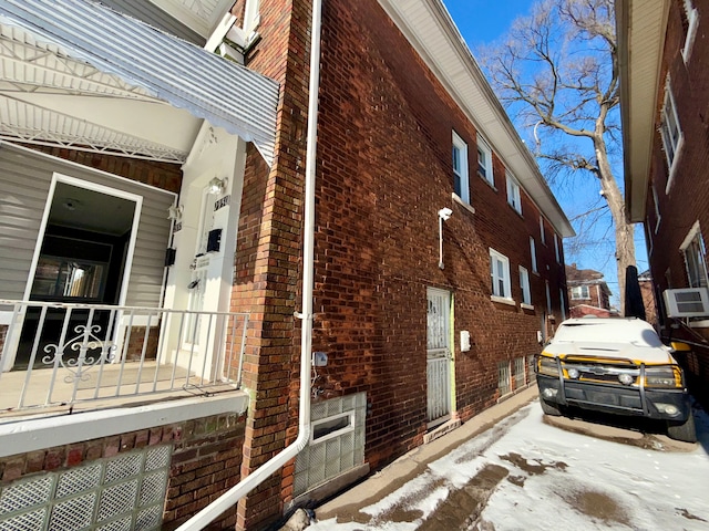 view of snow covered exterior with a wall mounted air conditioner