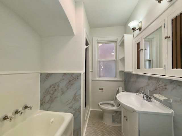 bathroom with tile walls, tile patterned flooring, a bathtub, vanity, and toilet