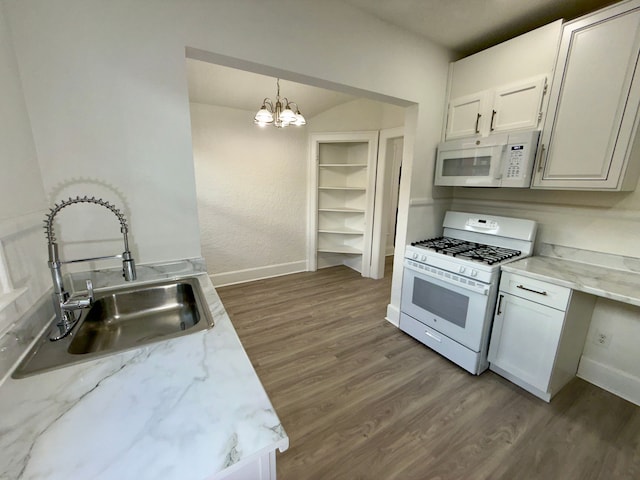 kitchen featuring sink, white appliances, dark wood-type flooring, hanging light fixtures, and white cabinets