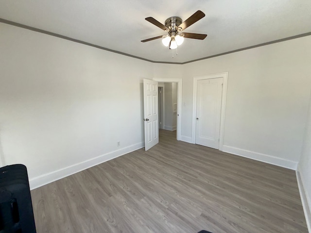 spare room featuring crown molding, ceiling fan, and wood-type flooring