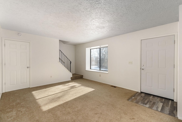 interior space with a textured ceiling and carpet