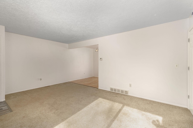 empty room featuring carpet and a textured ceiling