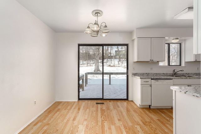 kitchen featuring sink, white cabinetry, light stone counters, white dishwasher, and pendant lighting