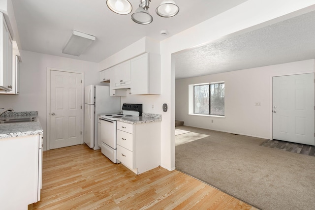 kitchen with sink, white appliances, white cabinetry, a textured ceiling, and light colored carpet