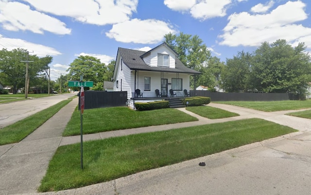 bungalow-style home with a porch, fence, and a front lawn