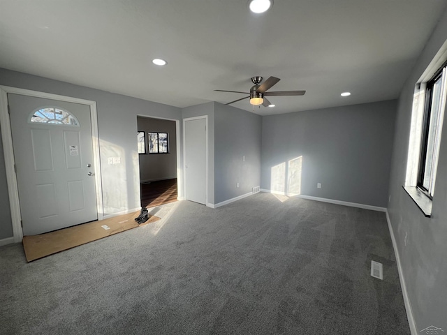 entrance foyer featuring carpet floors, a healthy amount of sunlight, and ceiling fan