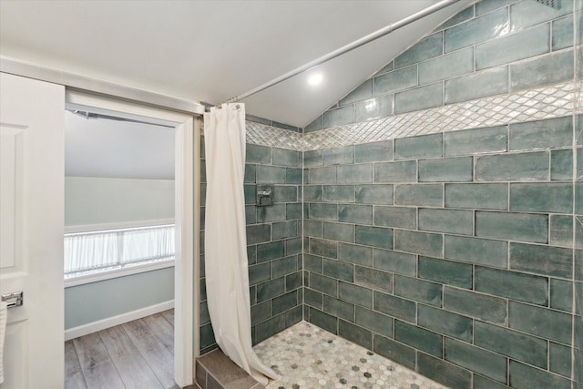 bathroom featuring walk in shower, lofted ceiling, and hardwood / wood-style floors