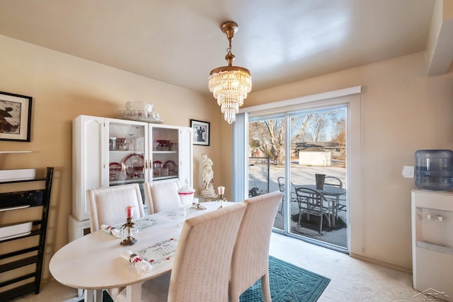 dining area with a notable chandelier and light colored carpet