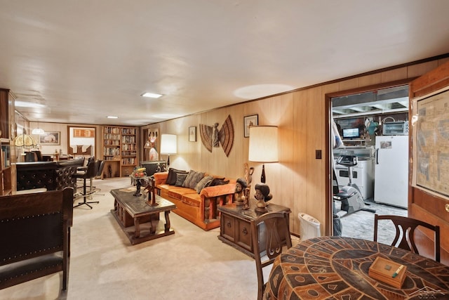 living room with ornamental molding and wooden walls