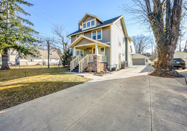 american foursquare style home featuring a garage, an outdoor structure, a front yard, and fence