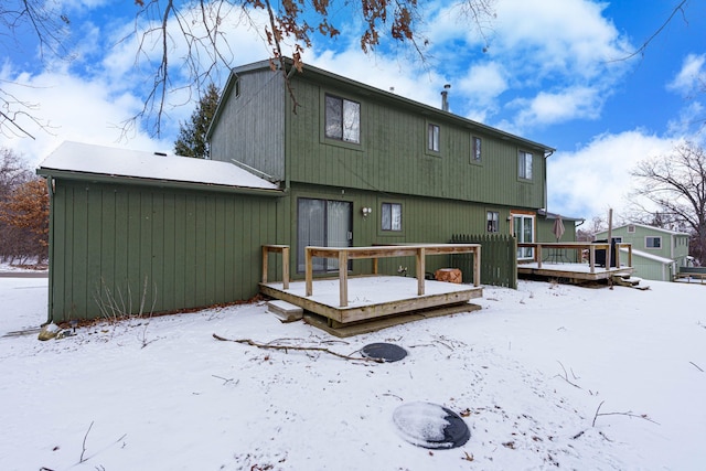 snow covered house with a wooden deck