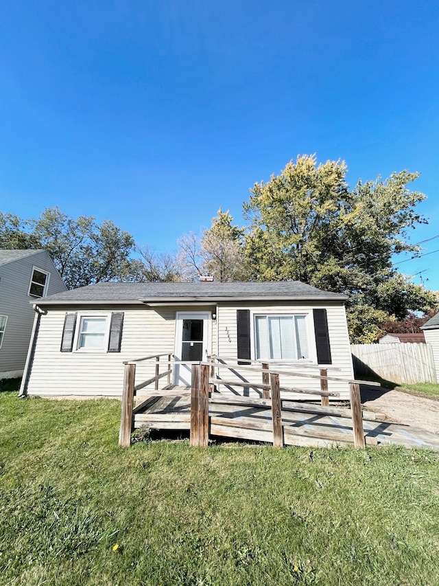 view of front of home featuring a front lawn and a deck